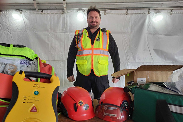 Construction medic with red and green medical bag